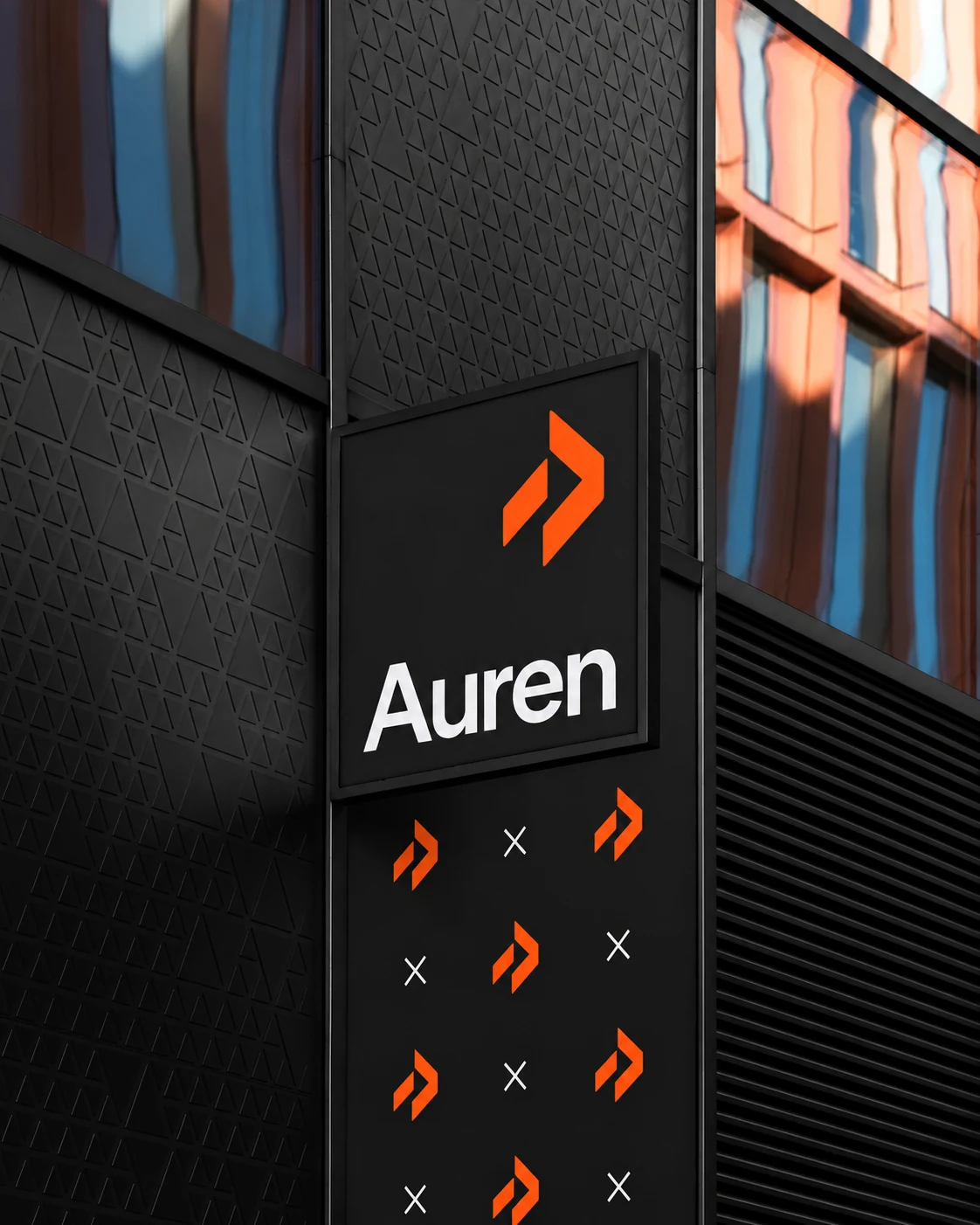 Auren's orange symbol and white wordmark on a dark building facade with patterned architectural panels.