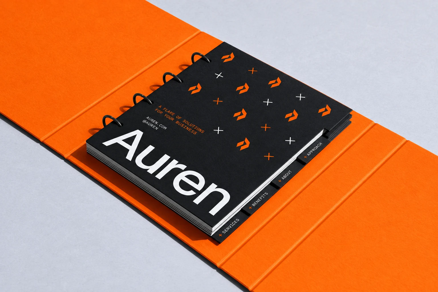 A ring-bound black Auren brand booklet with an orange folder and patterned cover.