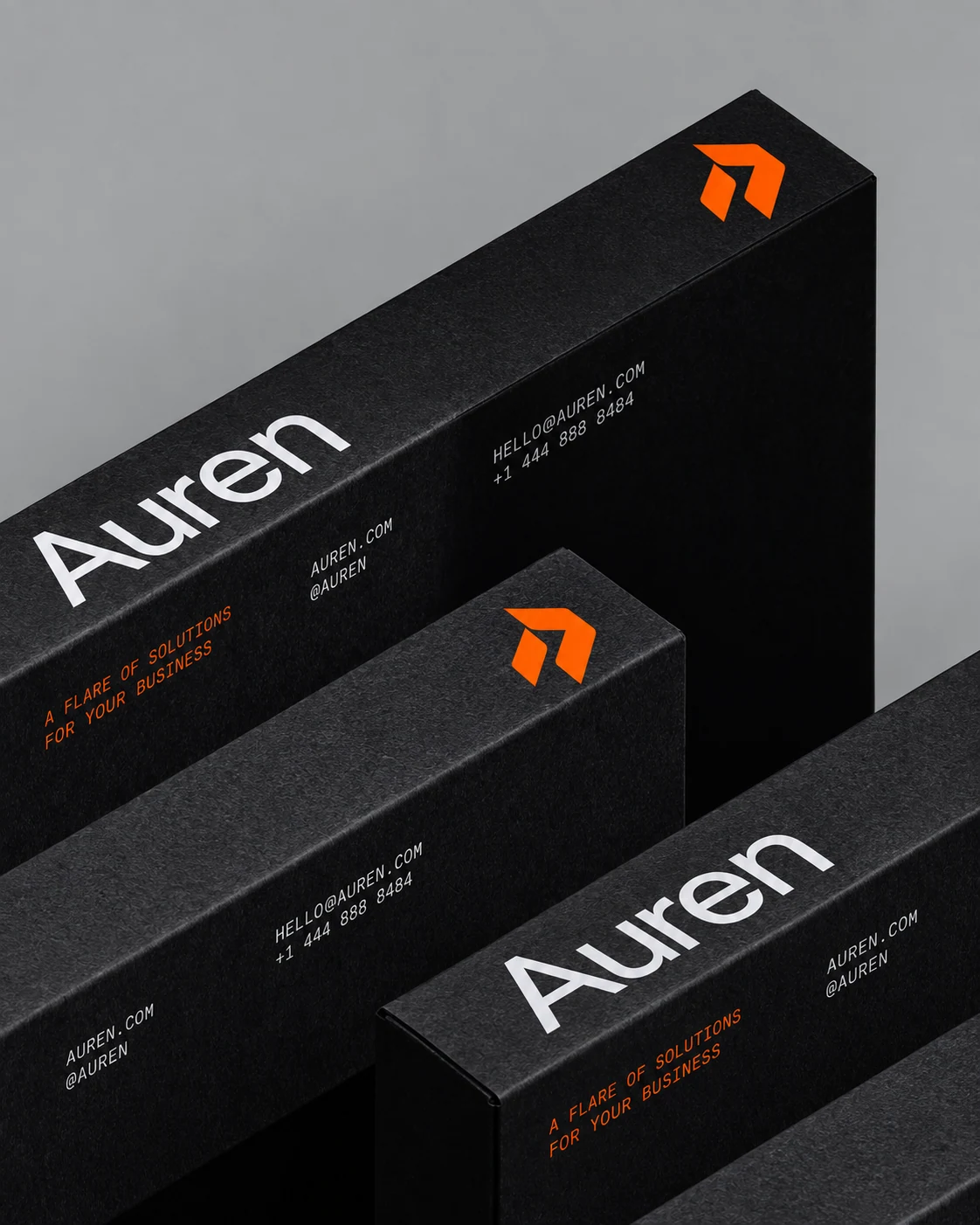 Close-up of textured charcoal Auren packaging with white wordmarks and orange symbols.